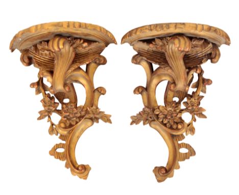 A PAIR OF ROCOCO STYLE CARVED GILTWOOD AND GESSO WALL BRACKETSlate 19th century, a demi-lune shelf with scrolling acanthus le