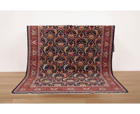 AN ANTIQUE PERSIAN TABRIZ CARPET&nbsp;woven in colours with endless leaf repeat on a dark blue ground, signed within a star t