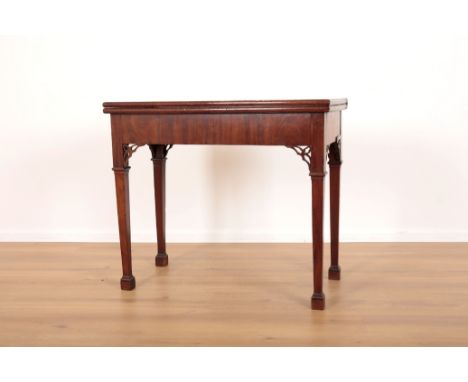 A GEORGE III MAHOGANY GAMING TABLEwith pierced corner brackets of Chippendale influence, terminating on tapered square legs w