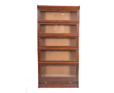 A mahogany five section bookcase of Globe Wernicke type with hinged glazed panel fall fronts, fitted with a cushion frieze dr