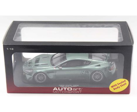 Auto Art Performance 1/18 scale modern issue diecast model of a Aston Martin DBR9 in dark mettalic green body, housed in a pl