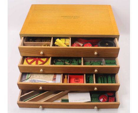 Original Meccano 1960s Outfit No.10, 4 drawer oak cabinet with white plastic handles, containing red, green, brass and base m