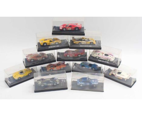 12 1:43 scale Solido vehicles including a Mirage Ford, a Ligier iS3, a Porsche 917 K, and others, all housed in their plastic