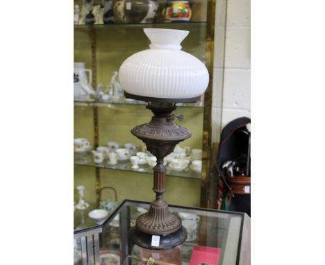 A Victorian copper oil lamp with opaque glass shade.