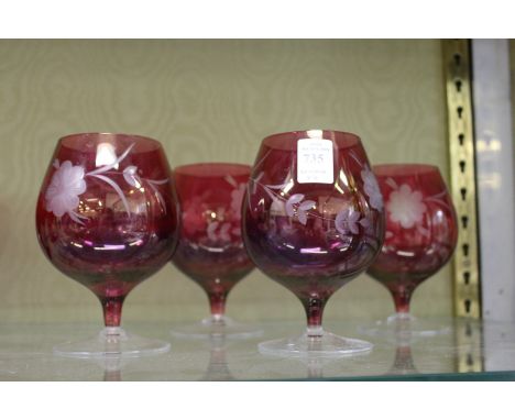 A set of four etched ruby glass brandy balloons.