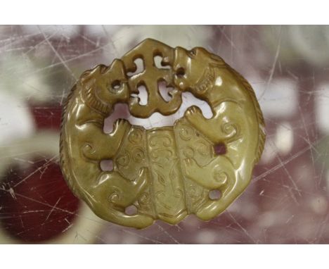 A Chinese armorial shaped carved jade pendant.