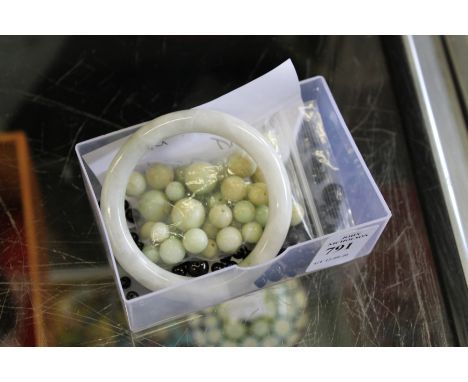 A jade bangle and similar beads.
