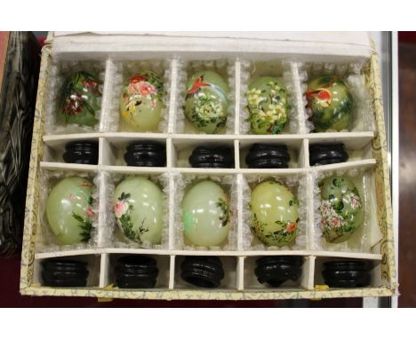 A boxed set of ten Chinese painted jade eggs on stands.
