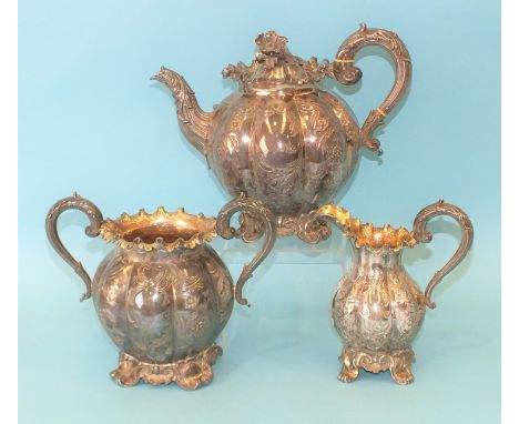 A Victorian three-piece silver tea service of melon form, with floral and scroll repoussé decoration, flowerhead finial and f