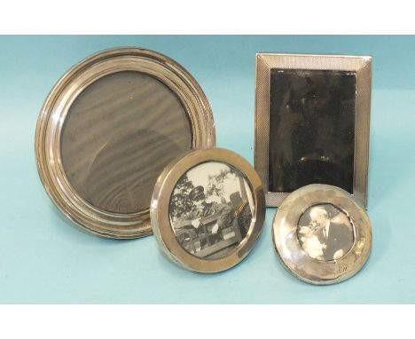 A small engine-turned silver photograph frame, 7.3 x 9.8cm, Birmingham 1950 and three circular silver photograph frames, 12cm