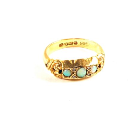 An 18ct Gold ring set with pierced scrollwork shoulders set with three small Opals and four small Diamonds (small chips to on