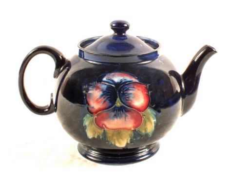 A Moorcroft Pansy pattern teapot on blue ground, with marks to base