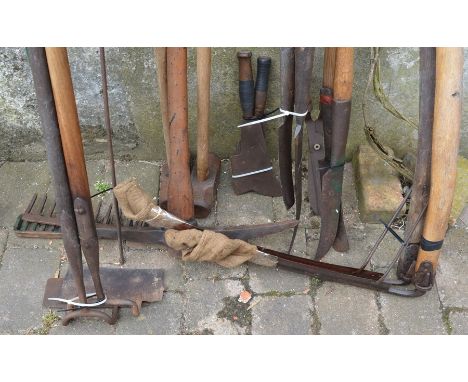 Vintage tools including scythes, billhooks, pick axe, 2 sledge hammers, hedge cutters, hoes &amp; rakes