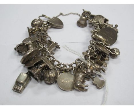 A Curb Link Charm Bracelet, to heart shape padlock clasp, suspending numerous novelty charm pendants, including well, mini ca