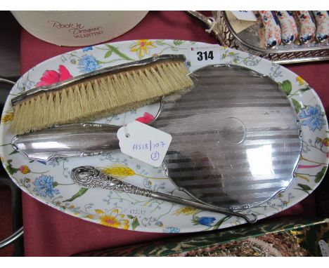 A Hallmarked Silver Mounted Hand Mirror, engine turned, together with a brush and a button hook. (3)