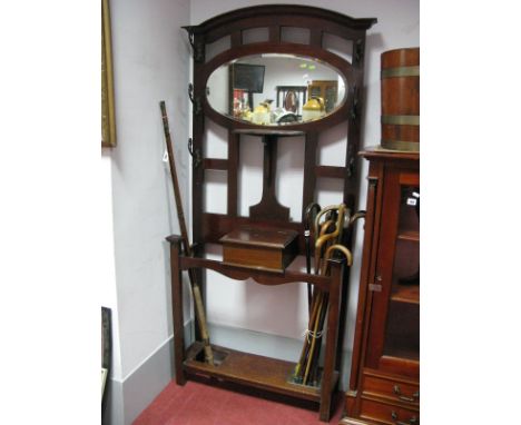 Early XX Century Mahogany Hat and Coat, stand with oval mirror, shaped shelf and oxidized hooks (one damaged). 