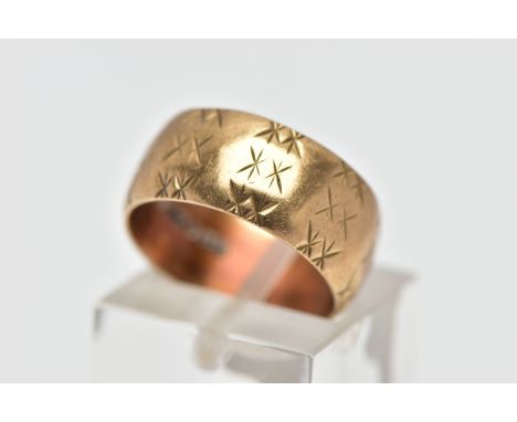 A 9CT GOLD TEXTURED BAND RING, yellow gold wide band with an engraved repetitive star pattern, approximate band width 8.0mm, 