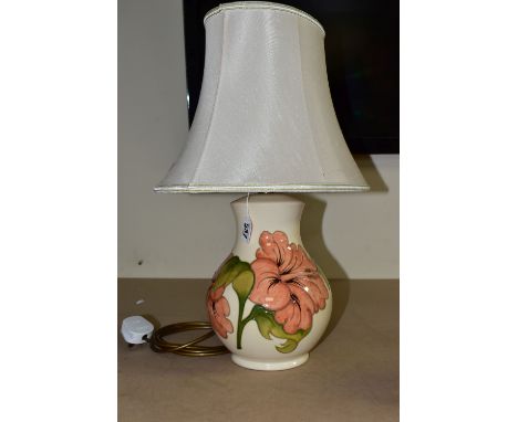 A MOORCROFT POTTERY TABLE LAMP BASE DECORATED WITH A CORAL 'HIBISCUS' DESIGN ON A CREAM BACKGROUND, with cream shade, height 