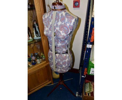 AN ADJUSTABLE DRESSMAKER'S MANNEQUIN, female form, in paisley print fabric, raised on a wooden support on three legs (1) (Con