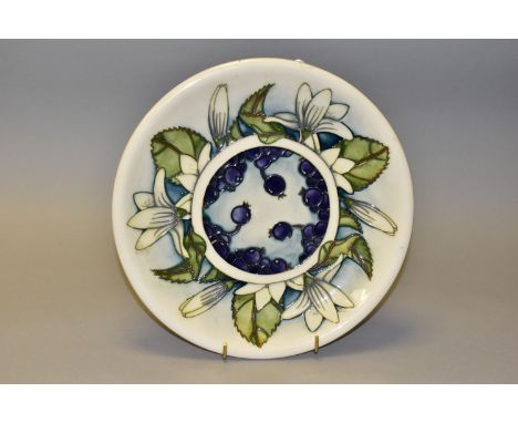 A MOORCROFT POTTERY JUNEBERRY PATTERN CHARGER, decorated with flowers and berries on a cream ground, impressed and painted ma