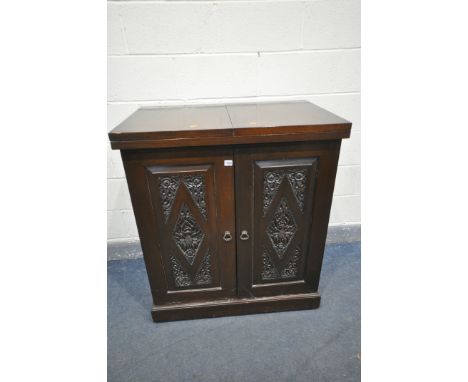 A 20TH CENTURY THAI ORIENTAL HEAVILY CARVED STAINED TEAK COCKTAIL CABINET, with a double fold over top above cupboard doors t