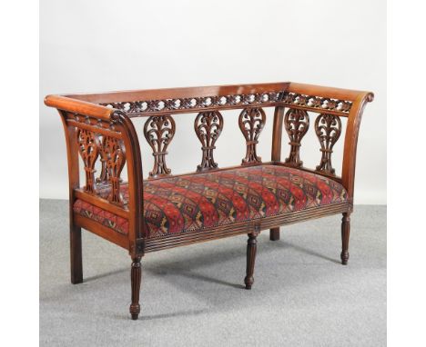 An antique style show frame sofa, with red geometric upholstery, retailed by Harrods, 149cm