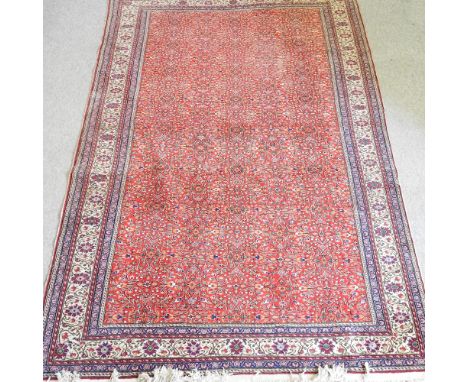 A Persian woollen carpet, with all over foliate designs, on a red ground, 300 x 203cm