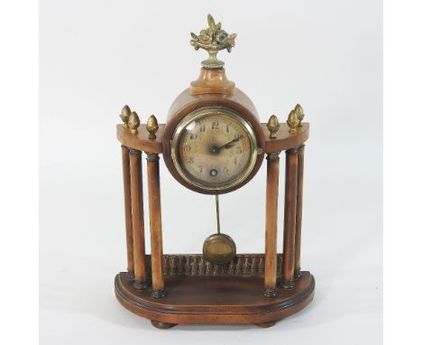 An early 20th century walnut cased portico clock, 21cm, together with The Clock Repairers Handbook, showing the clock on the 