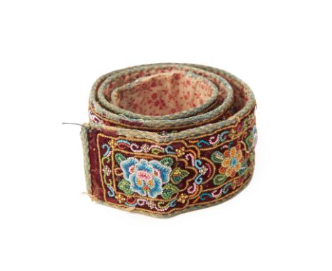 A PERANAKAN BEADED BELT A bead embroidered belt of maroon background, the design featuring flowerheads, foliage and insects 6