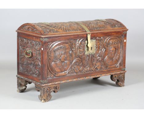 An 18th century French walnut domed trunk, finely carved with coats of arms, initials and further regalia to the lid, the fro