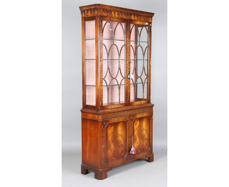 A late 20th century Bevan Funnell mahogany display cabinet, the moulded pediment above astragal glazed doors, the base fitted