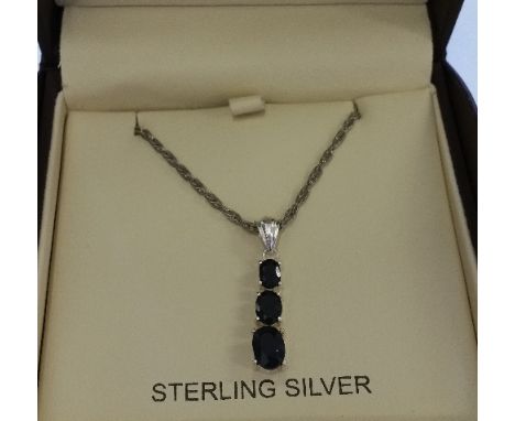 A Silver Sapphire Pendant On A Silver Chain.