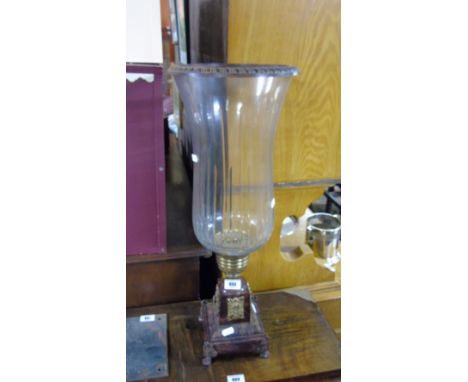 A Large Shaped Glass Storm Lantern of Conical Shape standing on a decorative square pedestal base.