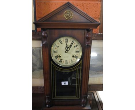 A Wall Clock with Simulated Column Supports; with a 31 day striking movement beneath an architectural frieze.