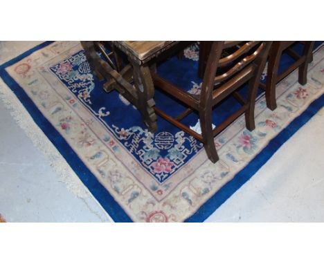 An Oriental Carpet on Blue and Cream Ground; with multi borders.