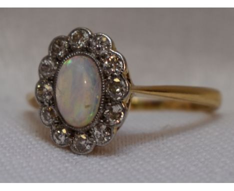 A lady's dress ring having an opal and diamond cluster in a pave mount on a yellow metal loop stamped 18ct, size M
Condition 