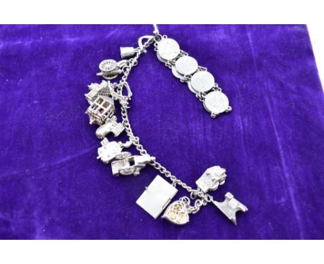 A silver charm bracelet having twelve silver and white metal charms including cine camera, Gretna anchor etc, and an eight co