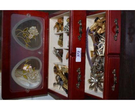 A jewellery chest containing a selection of costume jewellery including watches, earrings etc