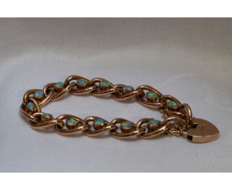 A Victorian rose gold and opal bracelet stamped 9ct having thirteen oval links having central opals and a padlock clasp
Condi