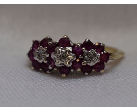 A lady's dress ring having a trio of ruby and diamond clusters on a 9ct gold loop,  size K/L