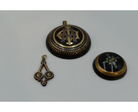 A large Victorian tortoise shell and pique pendant, a small similar pendant and a similar circular cabouchon panel