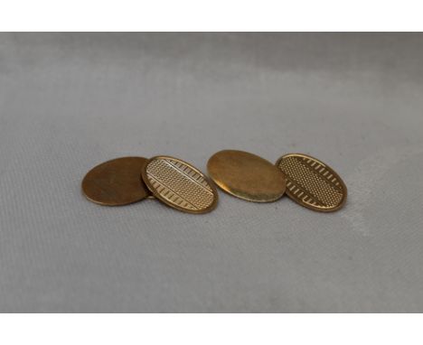 A pair of 9ct gold cufflinks of oval form having engine turned decoration to one oval with chain link connectors to plain ova
