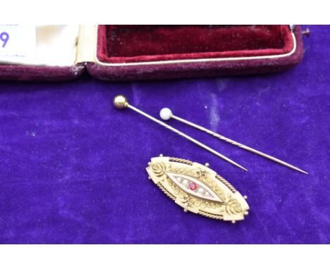 A 9ct gold bar brooch of oval form having central ruby flanked by seed pearls and wire decoration with locket to reverse and 