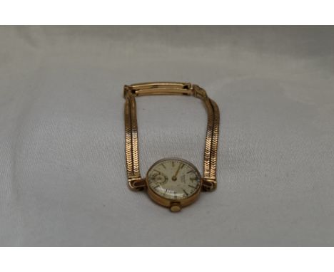 A lady's 9ct gold wrist watch by Movado having a baton numeral dial and 9ct gold snake chain bracelet,  approx 18g