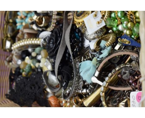 A basket of costume jewellery including bracelets, hair clips etc