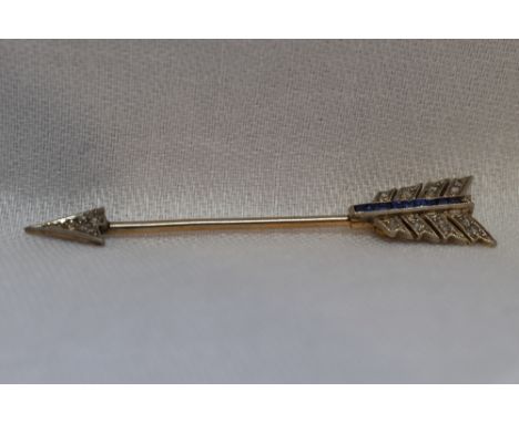 An Edwardian princess cut sapphire and old cut diamond set jabot pin in the form of an arrow set in white and yellow metal, n