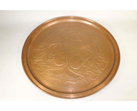 A KESWICK SCHOOL ARTS AND CRAFTS COPPER PLAQUE of plain circular form, chased with stylised flowering tulips, maker's stamp, 