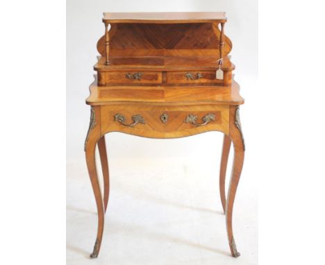 A NAPOLEON III BONHEUR DU JOUR, c.1900, in kingwood and tulipwood, of oblong serpentine form with gilt metal mounts, the uppe