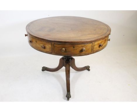 A REGENCY MAHOGANY DRUM TABLE, the revolving top with ebony stringing, the frieze with four drawers and four dummy drawers ha