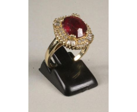 A RUBY AND DIAMOND CLUSTER RING, the oval facet cut ruby claw set to a border pave set with numerous small round brilliant cu